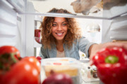 Woman reaching for food in fridge
