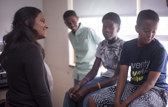 Giselle Danger-Mercaderes smiles as she talks to three boys.