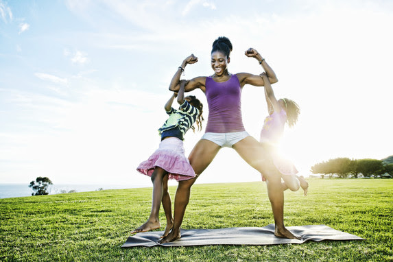 Woman exercising and playing with daughters