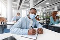 Black male student in mask at desk