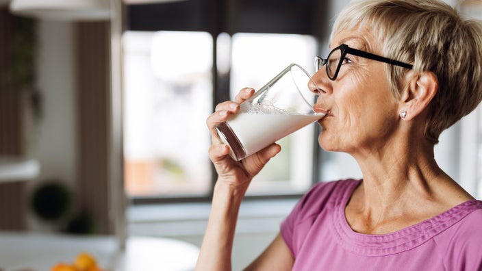 Photo of a mature woman drinking a glass of milk