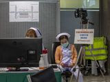 In this Tuesday, Feb. 18, 2020, photo, Thai public health officers operate a health checkpoint with thermo scan, targeting to pick people traveling with fever, a symptom of COVID-19 at Suvarnabhumi International airport in Bangkok, Thailand. Thai Public Health Ministry on Monday, Feb 17, 2020, informed Thais to reschedule their visits to Japan and Singapore citing the rising number of people infected by new coronavirus in those two countries. (AP Photo/Gemunu Amarasinghe)
