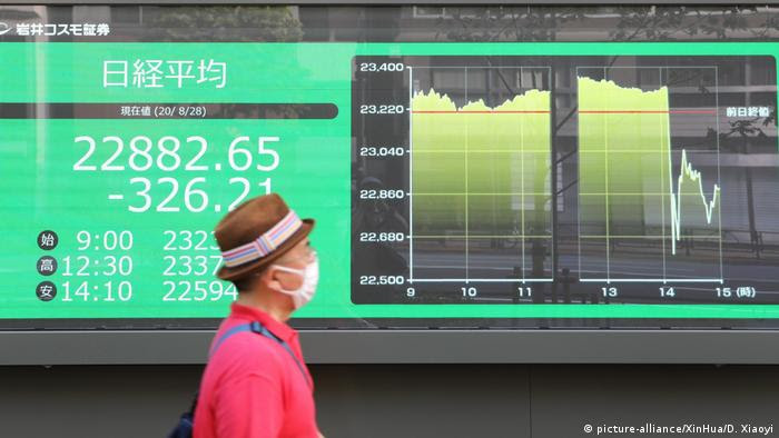 Homem observa curva descendente da bolsa de valores japondesa