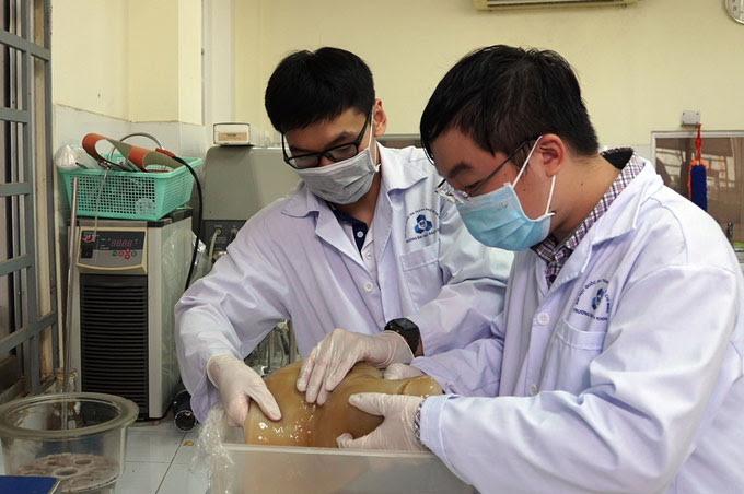 Nhóm sinh viên kiểm tra lớp màng CNC được tạo ra từ bùn giấy trong phòng thí nghiệm.