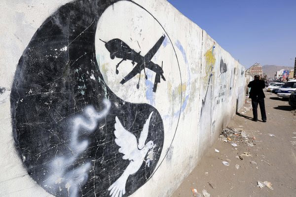A Yemeni walks past a graffiti protesting US military operations in the country on Jan. 29. (Yahya&nbsp;Arhab/EPA)</p> 