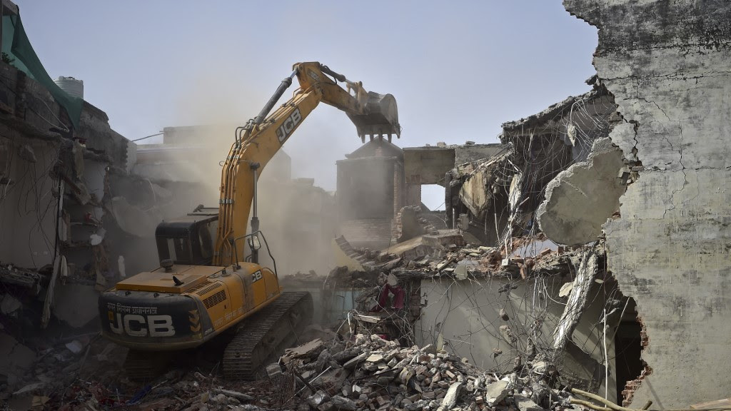 A bulldozer demolishes the residence of a local leader who was allegedly involved in protests against the BJP in Allahabad, India, on 12 June 2022 (AFP)