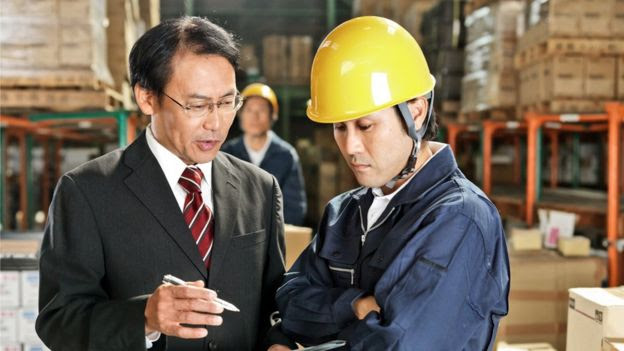 Trabalhadores japoneses conversam em depósito