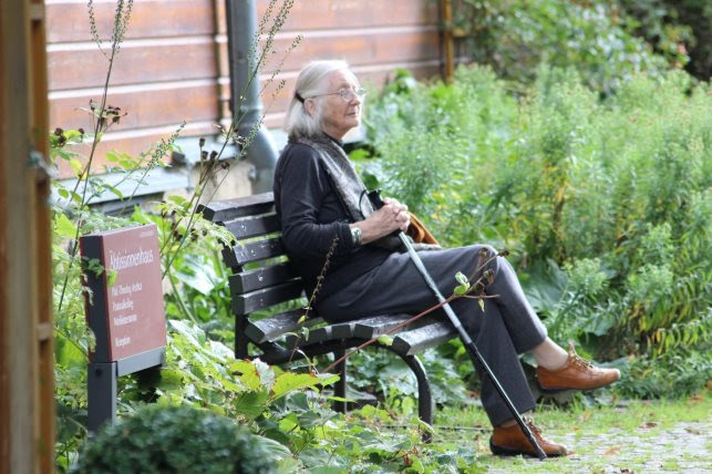 A statue of a person sitting on a bench

Description automatically generated