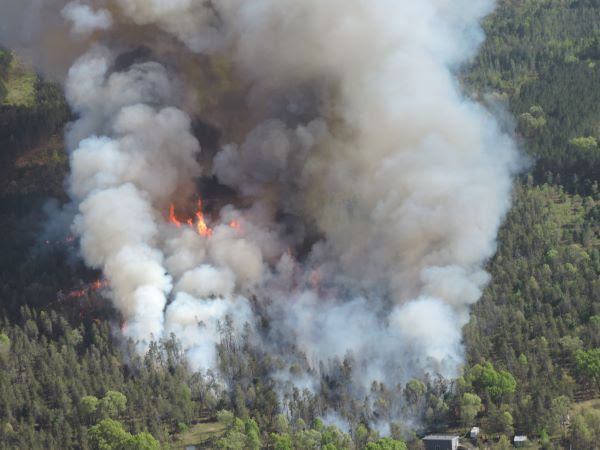Columns of smoke and flames cross the landscape during the Fife Lake Outlet Fire on May 28, 2023. 