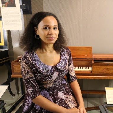 Rebeca Omordia seated by an 18th century virginal in the Music Gallery