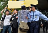Tokyo Electric Power Co (TEPCO) staff (2nd L) and security guards push back anti-nuclear activists from the entrance to TEPCO's shareholders meeting in Tokyo, on June 26, 2014