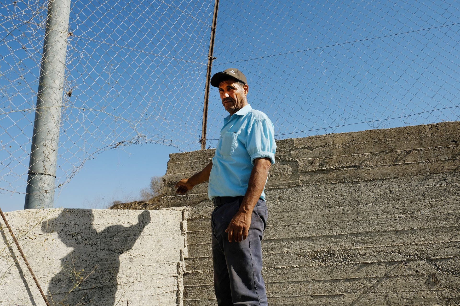 Abd al-Basath Ahmed next to the breached fence in Asira al-Qibliya.
