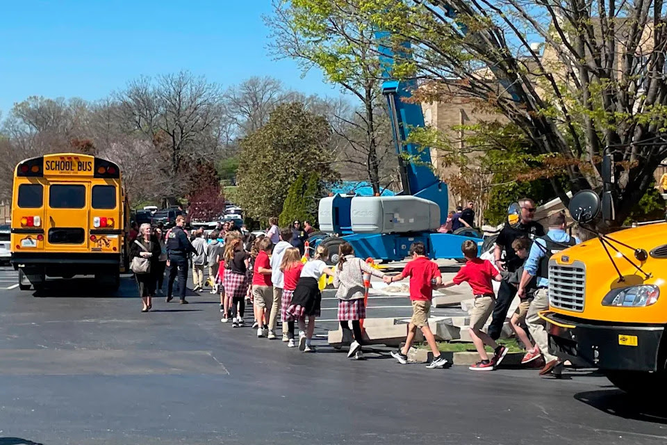 Children from The Covenant School, a private Christian school in Nashville, Tenn., hold hands as they are taken to a reunification site at the Woodmont Baptist Church after a shooting at their school, on Monday March, 27, 2023. (AP Photo/Jonathan Mattise)