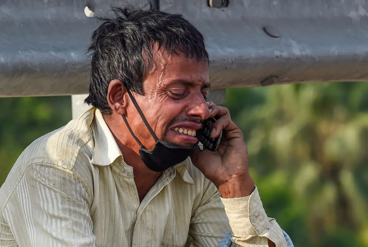 नई दिल्ली के निजामुद्दीन ब्रिज पर एक प्रवासी मजदूर अपने मोबाइल फोन पर एक रिश्तेदार से बात करते हुए रो पड़ा