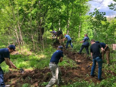 Local emergency response teams learn how to dig a trench for fire suppression