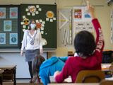 A teacher wearing protective face mask as she teaches close to pupils at a primary school in Morges, Switzerland, Monday, May 11, 2020. Swiss primary and secondary schools reopened with half of the students during the ongoing coronavirus Covid-19 pandemic. (Laurent Gillieron/Keystone via AP)