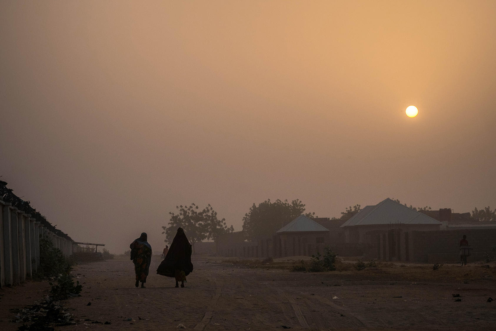 People walk in the early morning in Maiduguri, Nigeria, where many refugees from the conflict with the Boko Haram group have fled. (Ashley Gilbertson/The New York Times)