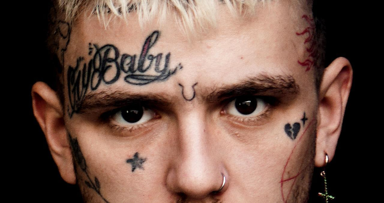 Lil Peep, a young guy with face tattoos stares at the camera