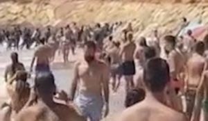 Video: Tourists watch as 50 Muslim migrants land boat on Spanish beach near luxury hotel