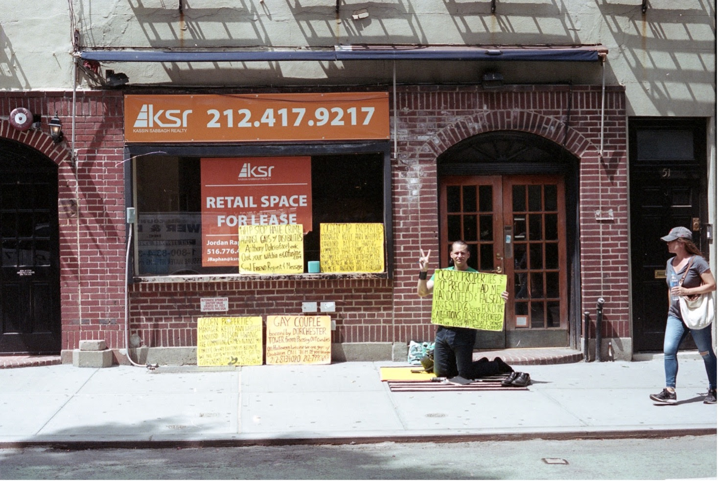 An activist holds space in front of the old Stonewall Inn during NYC Pride, where the city has allowed gentrifiers to push out LGBTQ+ tenants. (2019)
