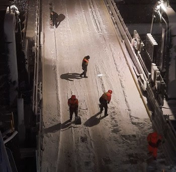 Photo of people shoveling snow at a ferry terminal