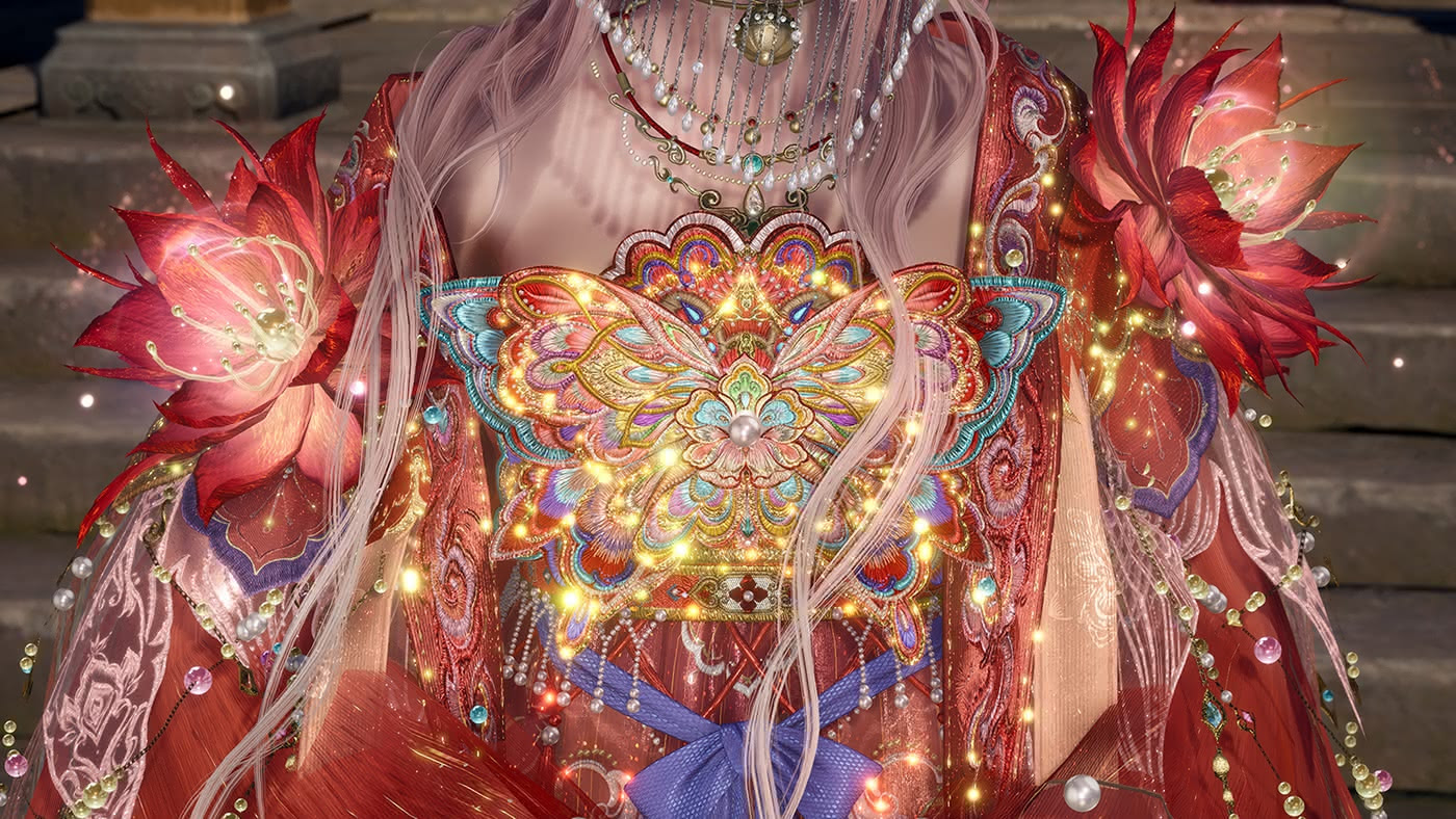 A close-up screenshot from Infinity Nikki, showing the torso of a female character with long silver-white hair, wearing an extraordinarily ornate red costume. The centerpiece is a large embroidered bodice panel featuring a glowing butterfly motif rendered in gold, teal, and multicolored thread, surrounded by radiating golden light particles and scattered pearl-like beads. Large crimson flower ornaments adorn each shoulder, and layered pearl necklaces drape across the neckline.