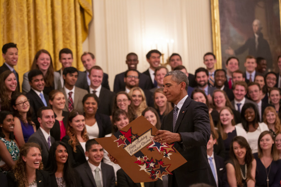 President Obama receiving his birthday card from the White House interns.