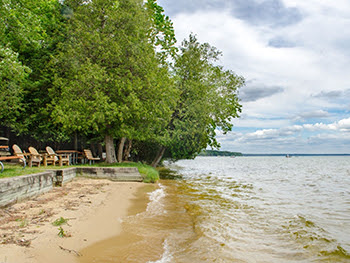 Chairs on the shore of Higgins Lake at RAM Center