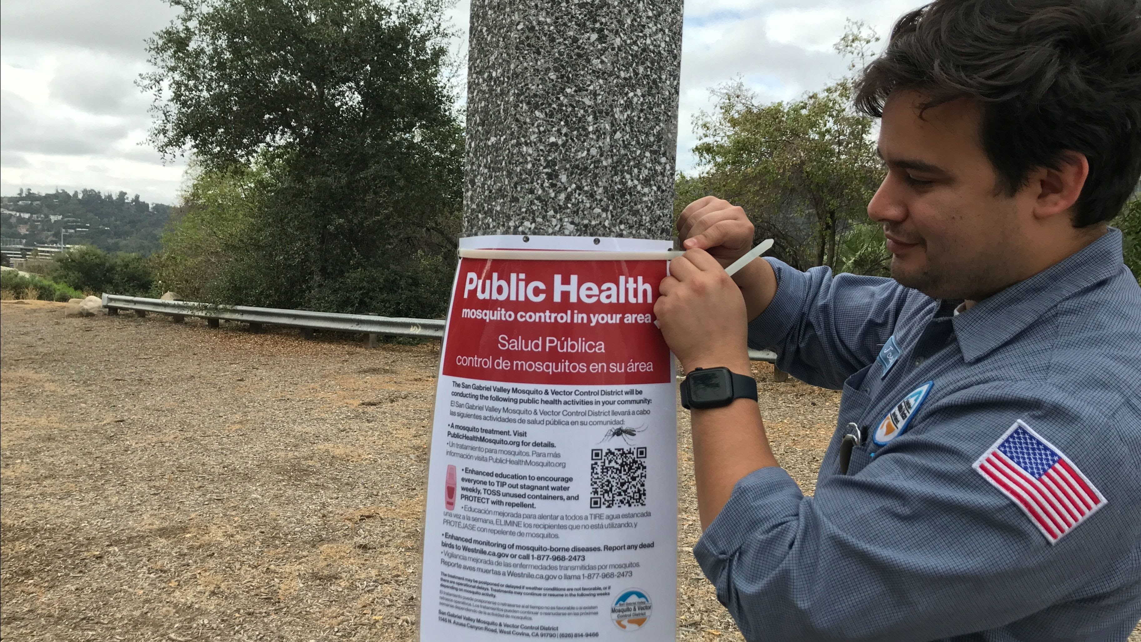 Image of a Technician posting a Treatment Notification sign in treatment area. 