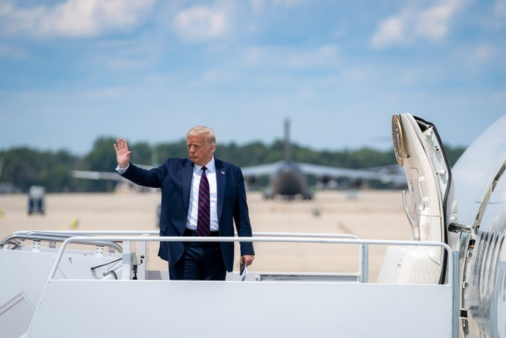 Donald Trump waving outside an airplane