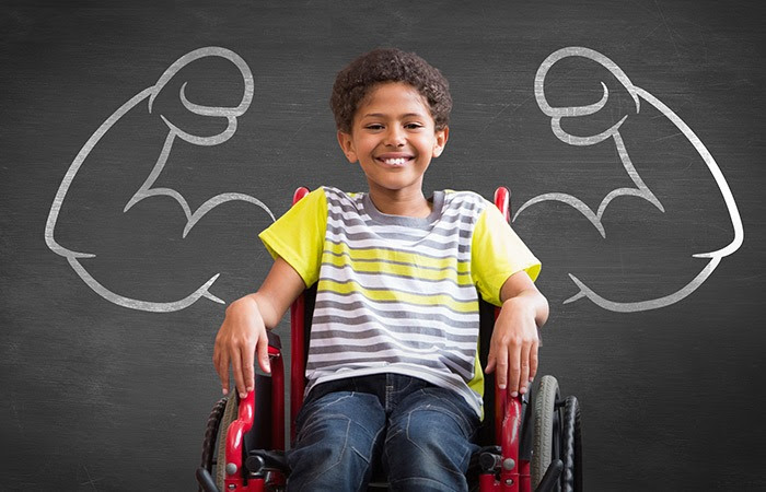 A young boy in a wheelchair in front of an illustration of strong arms flexing. 