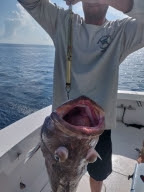 A person holding a grouper