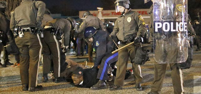 La policía detiene a un joven afroamericano durante las protestas en Ferguson