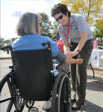 MRC volunteer helps woman in a wheelchair