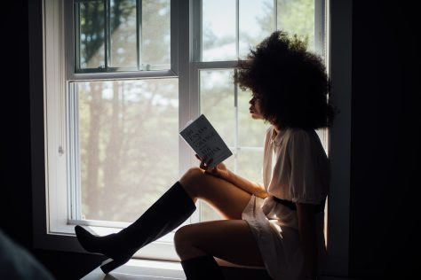 woman-sitting-on-window-reading-book-2228561