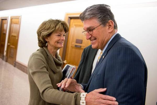 Sen. Joe Manchin III (D-W.Va.) stops in the hall to greet Sen. Lisa Murkowski (R-Alaska) before a Senate Energy and Natural Resources Committee meeting in 2015. (Andrew Harnik for The Washington Post)