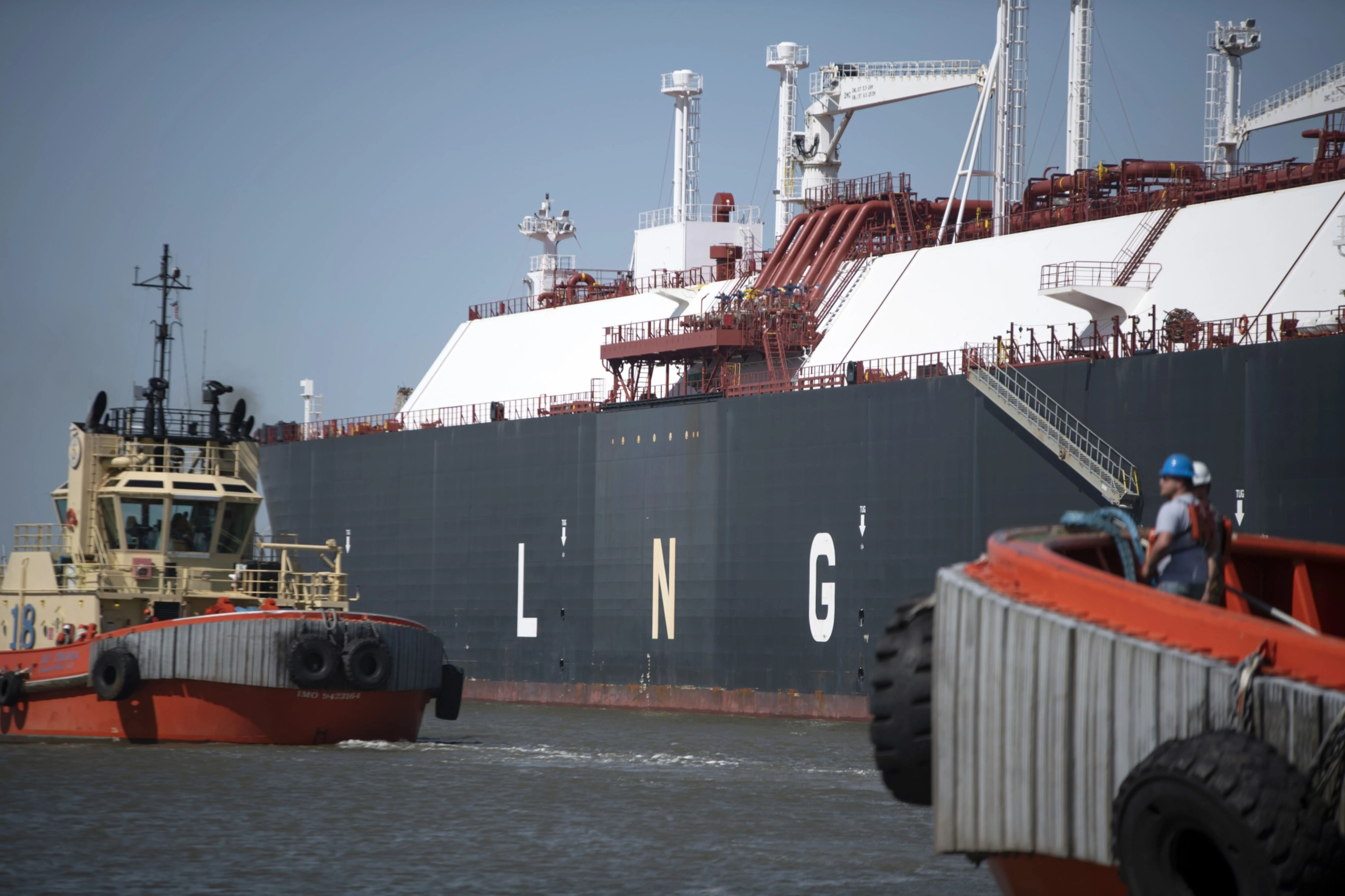Tug boats in April prepare to pull out an LNG tanker at the Cheniere Sabine Pass Liquefaction facility in Cameron, La.,
