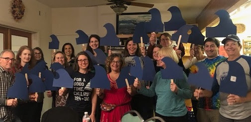 Indivisible Yolo members hold "blue wave" signs at the General Meeting