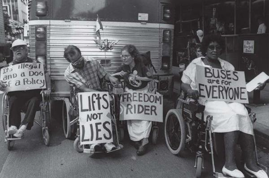 Protestors using wheelchairs protesting in favor of buses that accommodate people with disabilities.  