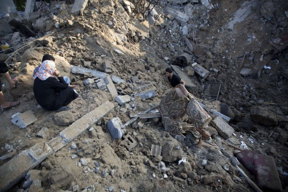 Un palestino recoge un mueble de entre los escombros de una casa destruida por Israel en Beit Hanu, al norte de la Franja de Gaza