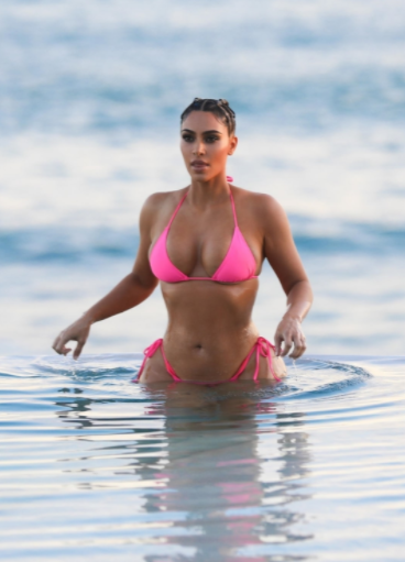 Kim Kardashain displays her curves in a skimpy pink bikini