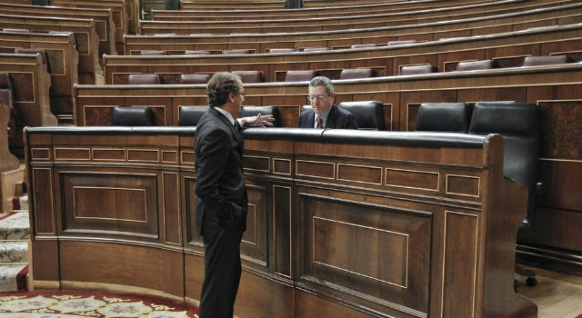 Alfonso Alonso y Alberto Ruiz-Gallardón conversan en el Congreso, prácticamente vacío. Archivo EFE.