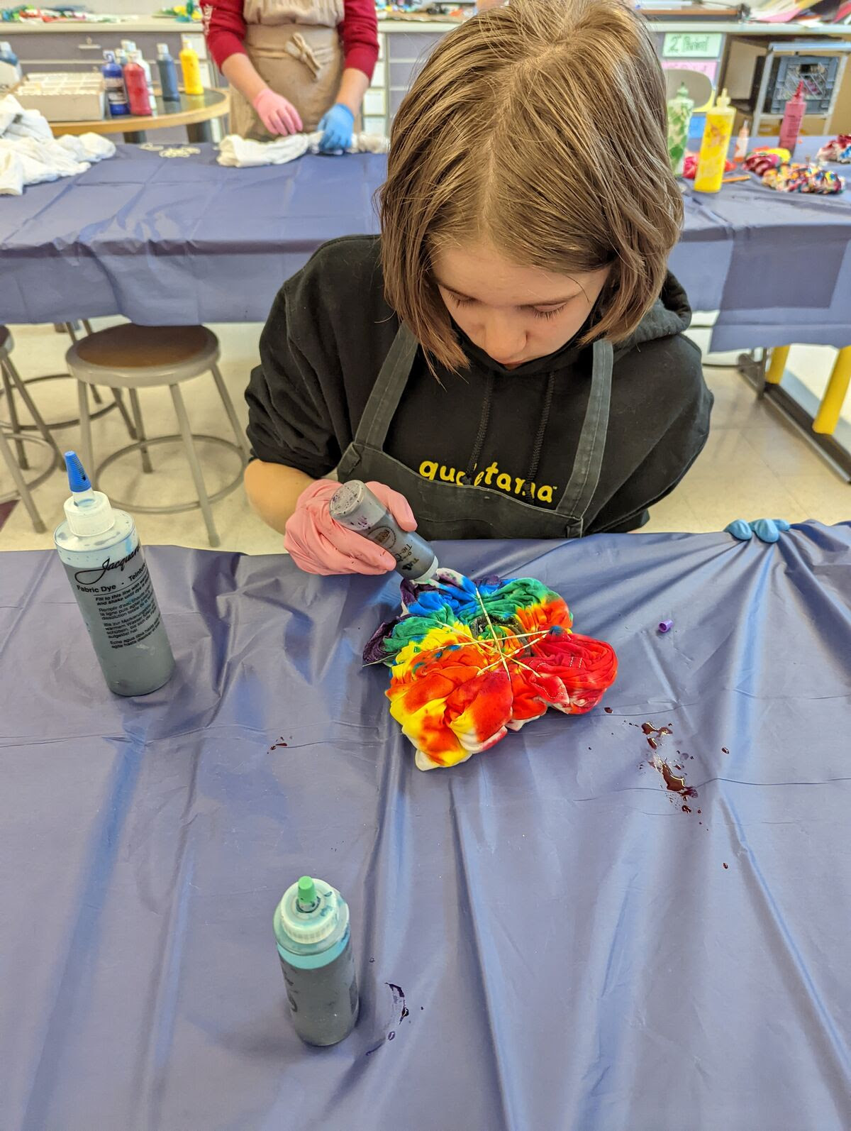 student tie dyeing a shirt