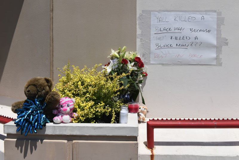 Hoa và gấu bông đặt bên ngoài cửa hàng nơi Dorn bị bắn chết cùng dòng chữ: "Các người đã giết một người da màu chỉ vì 'họ' cũng giết một người da màu ư??? Hãy yên nghỉ". (Ảnh: Getty Images)