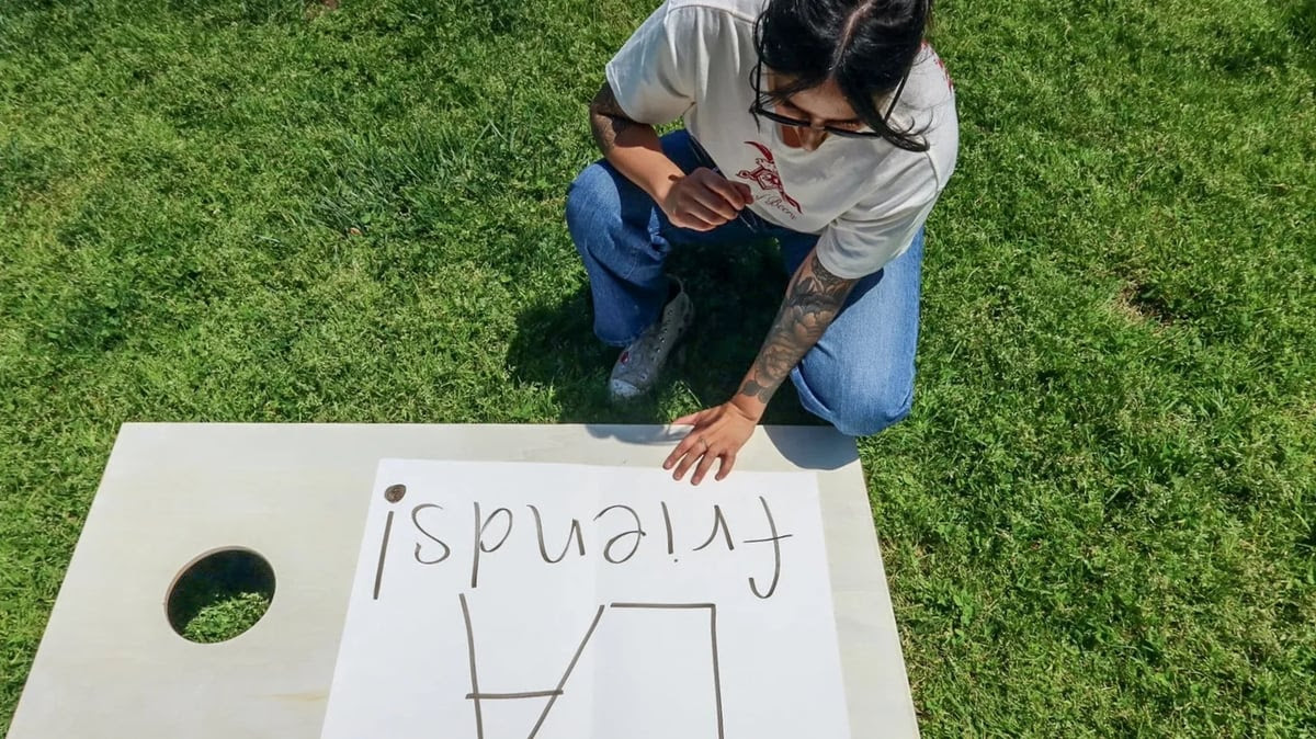 Emmely Avila makes a sign to help members of the Los Angeles Friends TikTok group find each other in person. Photo by Andrea Bautista