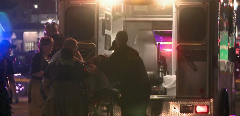 Screen shot of the video. EMTs loading a patient into the back of the ambulance