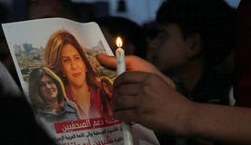 A Palestinian holds a picture of slain Palestinian-American Al Jazeera journalist Shireen Abu Akleh, during a candlelight event to condemn her killing, in front of the office of Al Jazeera network, in Gaza City, in May.