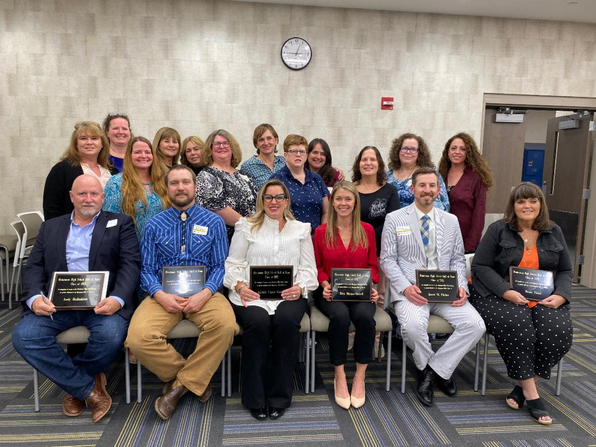 The 2022 Minuteman High School Hall of Fame Inductees at the conclusion of the ceremony. Front row, from left: Andy Rodenhiser, Tyler Faulkner, Kristin Lopez Cooper, Erin Dalzell, James Phelan, and Susan Flood. The back two rows include members of the 1984 Field Hockey Team.