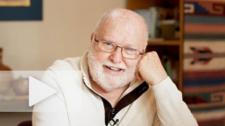A picture of Richard Rohr in a cream colored sweater smiling in his video for the 2021 Daily Meditations theme "A Time of Unveiling".