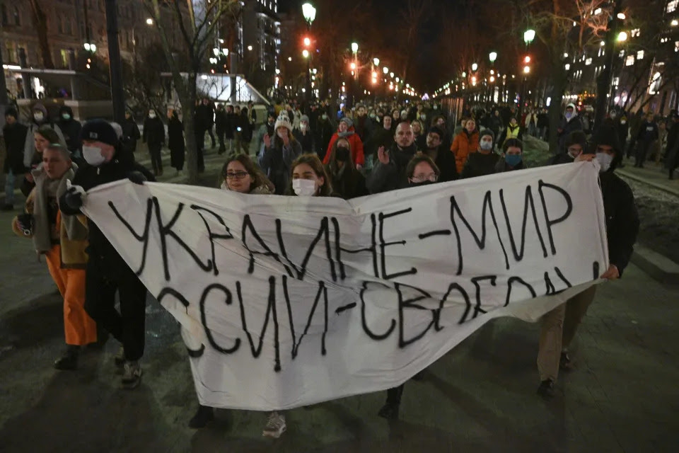 Demonstrators march with a banner that reads: Ukraine - Peace, Russia - Freedom, in Moscow, Russia, Thursday, Feb. 24, 2022, after Russia's attack on Ukraine. Hundreds of people gathered in the center of Moscow on Thursday, protesting against Russia's attack on Ukraine. Many of the demonstrators were detained. Similar protests took place in other Russian cities, and activists were also arrested. (AP Photo/Dmitry Serebryakov)